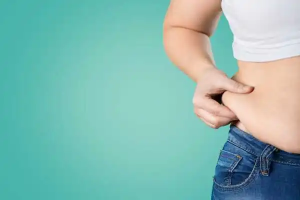 Image of woman pinching her love handles to show weight gain Marlborough